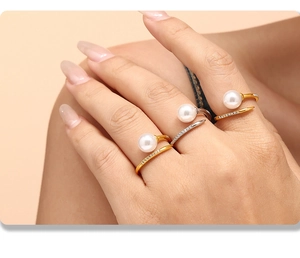 Close-up of elegant gold and silver open rings with pearls and sparkling pave zircons