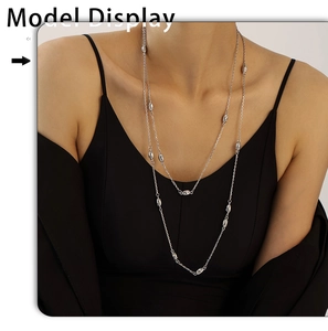 Silver double-layer sweater chain with oval geometric elements on a model