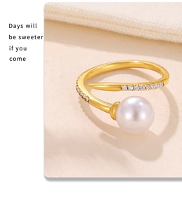 Macro shot of gold nail-shaped ring with a large pearl and sparkling pavé accents