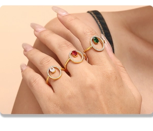 Macro shot of three luxury gold-plated rings with red, green and clear zircon stones