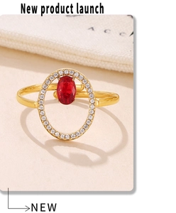 Macro view of adjustable gold-plated ring with red oval center stone and zircon pavé inlay