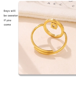 Close-up of golden geometric open ring with square-set crystal on warm fabric