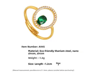 Detail of gold titanium steel ring with green oval gemstone and white zircon accents