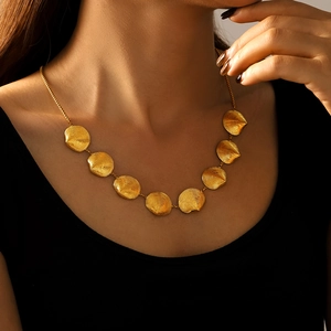 Goldene Muschelkette mit Spiraltextur und PVD-Beschichtung an einem weiblichen Model
