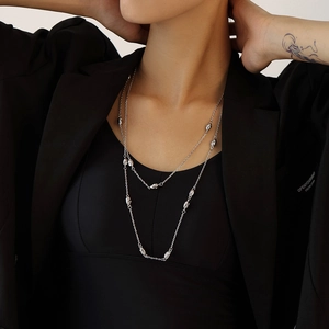 Silver double layer stainless steel long necklace with oval bean charms on a model