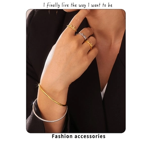 Dettaglio di modella con anelli a fiocco e bracciali minimalisti in acciaio al titanio