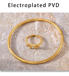 Dettaglio dell'anello con fiocco e bracciale minimalista in acciaio inossidabile PVD oro