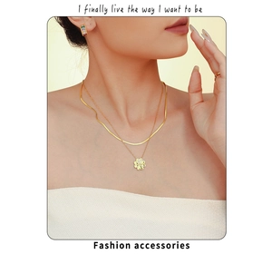 Detalle de collar de doble capa dorado con trébol y circonitas puesto en modelo