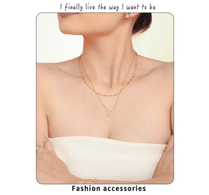 Détail de colliers dorés superposés avec pendentif cœur serti sur un mannequin