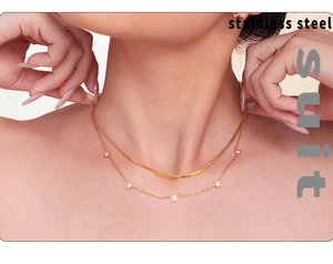 Detail of a double-layer gold stainless steel necklace with a star zircon pendant