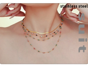 Detail of layered stainless steel necklace with lapis lazuli beads on model neck