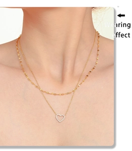 Effet porté d'un collier double épaisseur doré avec pendentif cœur serti de zircons