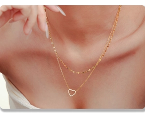 Gros plan du collier double épaisseur en or avec pendentif cœur serti de zircons