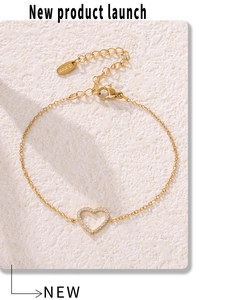 Gros plan sur un bracelet cœur doré avec zircons pavés et fermoir mousqueton en acier inoxydable