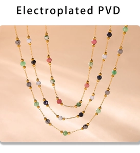 Macro detail of multi-layered PVD gold plated beaded necklaces on textured fabric
