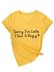 Detail of yellow V-neck T-shirt with 'Sorry I'm Late I Saw A Dog' print and knotted hem