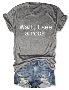Detail of dark grey t-shirt with 'Wait, I see a rock' text paired with denim shorts
