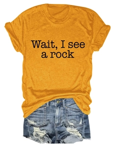 Flat lay detail of mustard yellow crewneck T-shirt with black text and distressed denim shorts