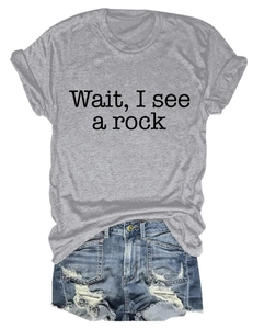 Detail of grey cotton blend t-shirt with 'Wait I see a rock' text and ripped denim shorts