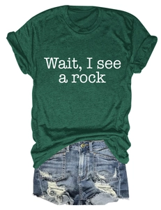 Detail of dark green t-shirt with Wait I See A Rock text and frayed denim shorts
