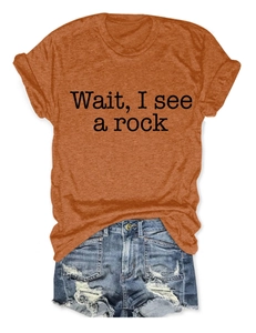 Detail of orange cotton T-shirt with Wait I See A Rock slogan and distressed denim shorts