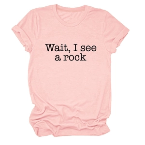 Close-up of pink cotton fabric texture and black 'Wait, I see a rock' print on t-shirt