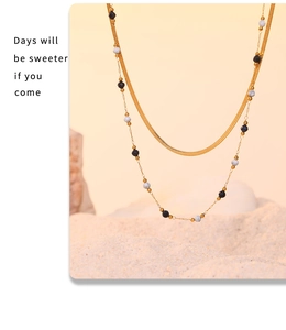 Macro shot of double-layer gold chain necklace with lapis lazuli beads and flat snake chain