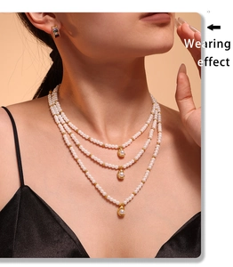 Collier de perles à trois rangs avec pendentifs dorés portés par un mannequin