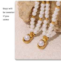 Détail du collier de perles en nacre plaqué or 18 carats sur fond de pierre beige