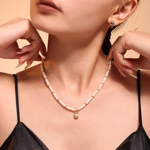 Collier de perles élégant avec pendentif doré et boucles d'oreilles en pierres