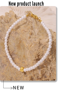 Detail of baroque pearl bracelet with gold bead accent on a natural stone background