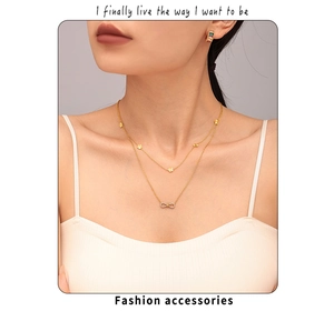 Detailed view of layered gold necklace with clover and bow charms worn by a model