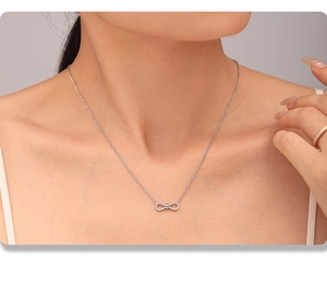 Macro shot of silver infinity necklace with sparkling zircon on model neck
