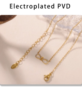 Close-up of golden PVD coated necklace with sparkling zircon bow pendant and clasp
