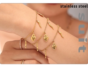 Detail of 18K gold plated stainless steel bracelet set with heart and horn charms