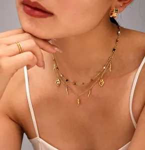 Detail of 18K gold-plated double-layer necklace with heart and chili charms and beads