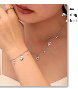 Wearing effect of silver heart and horn pendant necklace and bracelet set in 18K gold finish