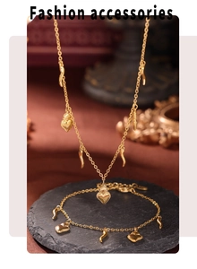 Detail of 18K gold plated necklace and bracelet set with heart charms on stone base