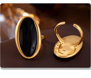 Detail of gold oval ring with black inlay showing the adjustable open back design