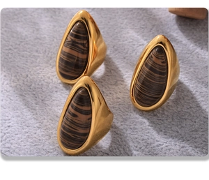 Macro detail of 18K gold-plated stainless steel rings with tiger eye stone texture