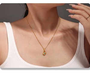 Primer plano de un collar de corazón dorado con piedra azul en el cuello de una mujer