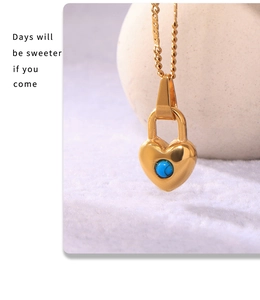 Vista macro del colgante de candado de corazón dorado con piedra turquesa y cadena