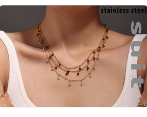 Detailed view of triple-layered gold stainless steel necklace with colored beads on model