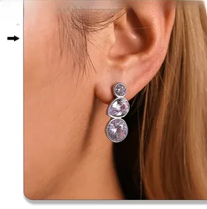 Close-up of geometric teardrop zircon drop earrings on model for a refined elegant look