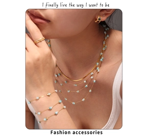 Detail of layered gold stainless steel necklace and bracelet set with amazonite stones