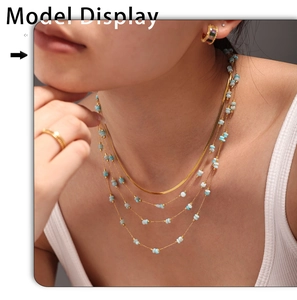 Close-up of layered gold snake chain and Amazonite beaded necklaces on a model