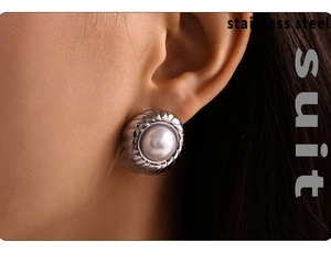Close-up of elegant pearl earrings with spiral silver steel edge on model ear