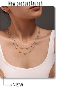 Detail of double-layer gold chain necklace with blue stone beads on Asian female model