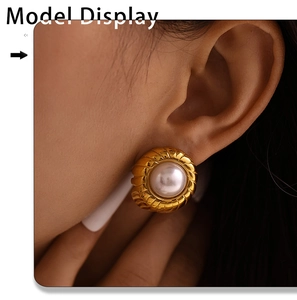 Close-up of elegant gold-plated spiral pearl earrings on model's ear with vintage style
