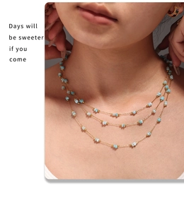 Detailed view of triple-layered gold chain necklace with light blue amazonite beads
